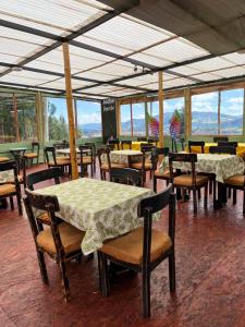 a dining room with tables and chairs and windows at GLAMPING RESERVA CATEDRAL Zipaquira in Zipaquirá