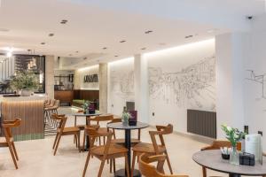 a restaurant with tables and chairs and a drawing on the wall at Amaranta Hotel Boutique in Ronda