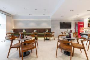 a restaurant with tables and chairs and a tv at Amaranta Hotel Boutique in Ronda