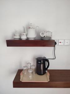 a shelf with a coffee pot and glasses on it at Hatton Easy Stay in Hatton