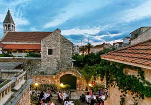 a group of people sitting outside of a building at Dimora Picco Bello in Trogir