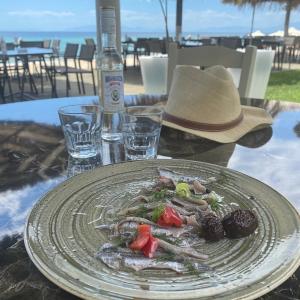 a plate of food on a table with a hat at Katerina Apartments in Flogita