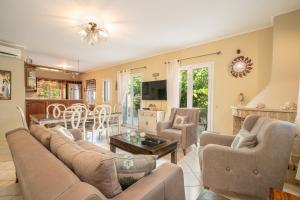 a living room with a couch and a table at Villa Regina -Hidden Eden with Treehouse & Heated Pool in Agia Effimia