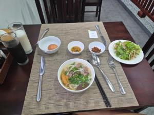 a wooden table with plates of food on it at Moonlight Boutique Hotel in Hue