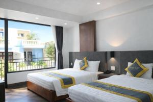 a hotel room with two beds and a balcony at Moonlight Boutique Hotel in Hue