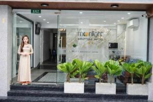 a woman standing in front of a store window at Moonlight Boutique Hotel in Hue +69 photos