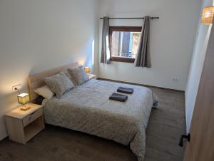a small bedroom with a bed and a window at Ca la Ministra in Amer