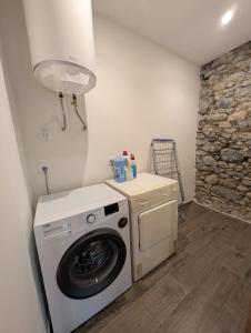 a washer and dryer in a room with a stone wall at Ca la Ministra in Amer +1 photo