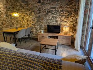 a living room with a couch and a tv and a table at Ca la Ministra in Amer