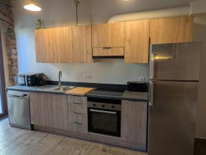 a kitchen with wooden cabinets and a stainless steel refrigerator at Ca la Ministra in Amer