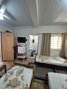 a dorm room with two beds and a tv at Pousada A CASA DE IRENE in Aparecida