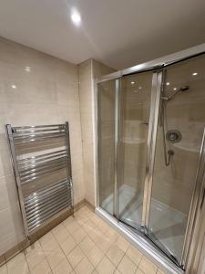 a shower with a glass door in a bathroom at Cavendish Hotel in High Wycombe