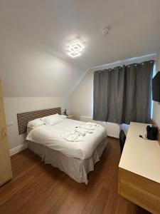 a bedroom with a white bed and a window at Cavendish Hotel in High Wycombe
