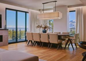 a dining room with a table and chairs and windows at Limelight Mammoth in Mammoth Lakes