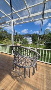 a swing on a porch with a house in the background at Villa Solara in Ko Phangan