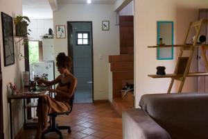 a woman sitting at a table in a room at Casa Kahlo in Lençóis