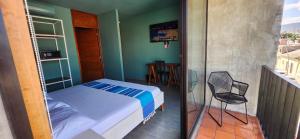 a small bedroom with a bed and a chair at Hotel Momotus Tuxtla, en el centro - Acceso autónomo in Tuxtla Gutiérrez