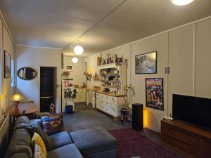 a living room with a couch and a television at Step-free modern central apartment in Todmorden