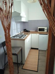 a small kitchen with a stove and a microwave at Malpensa - Bilocale indipendente in Samarate