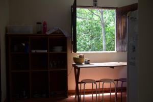 a kitchen with a table and stools and a window at Casa Kahlo in Lençóis