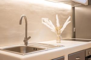 a kitchen sink with a vase of flowers on it at Little Yard Studios & Apartments #4 in Naxos Chora