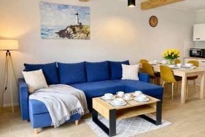 a living room with a blue couch and a table at Domki Przystań Kotwica in Jastrzębia Góra