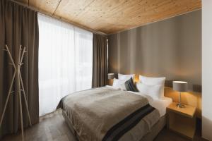 a bedroom with a bed and a large window at Skihotel Galzig B&B in Sankt Anton am Arlberg +84 photos