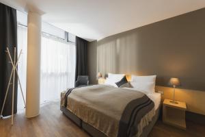 a bedroom with a bed and a large window at Skihotel Galzig B&B in Sankt Anton am Arlberg