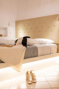 a bed with a black tie and shoes on it at Little Yard Studios & Apartments #4 in Naxos Chora