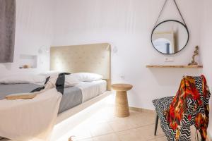 a bedroom with a bed and a mirror and a chair at Little Yard Studios & Apartments #4 in Naxos Chora +45 photos