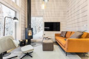 a living room with a couch and a fireplace at Villa Mokum by PolarVillas in Kittilä