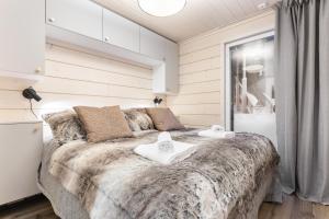 a bedroom with a large bed with towels on it at Villa Mokum by PolarVillas in Kittilä