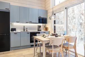 a kitchen and dining room with a table and chairs at Villa Mokum by PolarVillas in Kittilä