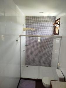 a bathroom with a glass shower with a toilet at Varanda das Palmeiras in Cairu