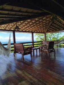 a pavilion with chairs and a table and hammock at Varanda das Palmeiras in Cairu