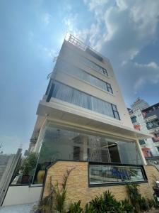 a tall white building with a glass facade at Raghav Residency in Vellore