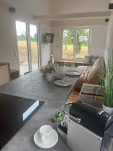 a kitchen and living room with a table with dishes on it at Tinyhaus Ferien in Eggolsheim