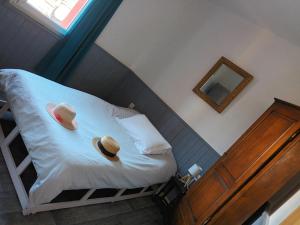 a bedroom with a bed with two hats on it at Maison de pêcheur in Marseillan