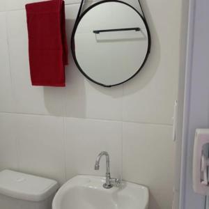 a bathroom with a mirror and a toilet and a sink at Recanto Antônio Costa in Paraty