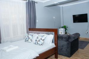 a bedroom with a bed and a leather couch at Patrach Homes in Wote