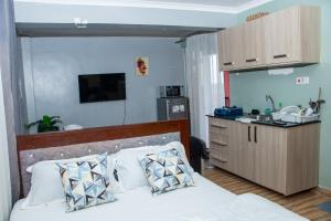 a bedroom with a bed and a small kitchen at Patrach Homes in Wote