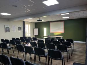 a room with chairs and a projection screen and a board at Brit Hotel L'Arrivée Guingamp in Guingamp