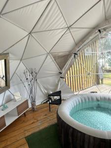 a tent with a hot tub in a room at GLAMPING RESERVA CATEDRAL Zipaquira in Zipaquirá
