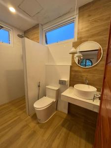 a bathroom with a toilet and a sink and a mirror at Villa Solara in Ko Phangan +4 photos