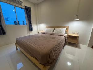 a bedroom with a bed with a night stand and a window at Villa Solara in Ko Phangan