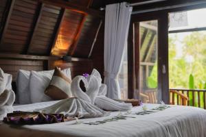 a bedroom with a bed with towels on it at Kelingking Terrace Cottage in Nusa Penida +32 photos