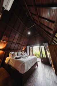 a bedroom with a bed in a room with a large window at Kelingking Terrace Cottage in Nusa Penida