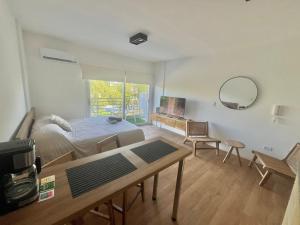 a bedroom with a bed and a table and a mirror at L&J Loft 1 ambiente in Belén de Escobar