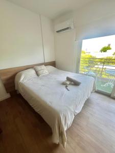 a bed in a room with a large window at L&J Loft 1 ambiente in Belén de Escobar