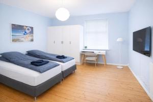 a bedroom with a bed and a desk and a television at Greenbrook Blue TwinSuite in Aalborg